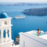 Woman in infinity pool overlooking Santorini Greece